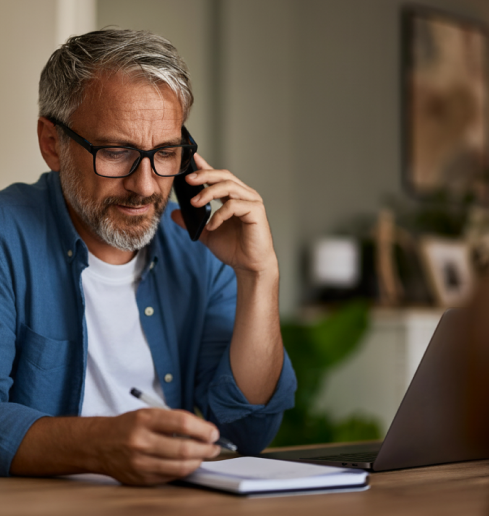 Persona atendiendo una llamada y tomando notas
