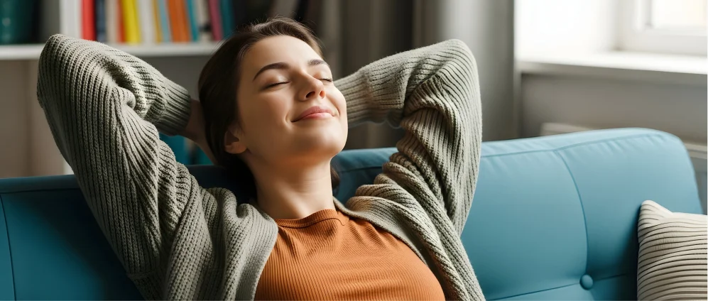 Mujer relajada en casa disfrutando de la estabilidad de su tarifa fija de luz con Factorenergia, sin preocuparse por los horarios ni cambios de precio.