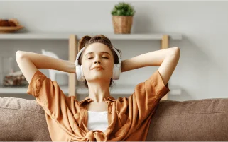 Mujer relajada en casa disfrutando de la estabilidad de su tarifa fija de luz con Factorenergia, sin preocuparse por los horarios ni cambios de precio.