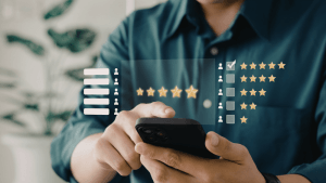 Persona utilitzant el seu telèfon mòbil per revisar un gràfic digital de valoracions de cinc estrelles, mostrant com analitzar les opinions d'una comercialitzadora de llum