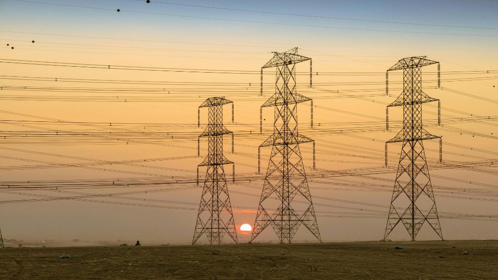 Torres d'alta tensió i estesa elèctrica al capvespre representant la distribució d'energia al mercat lliure de la llum.